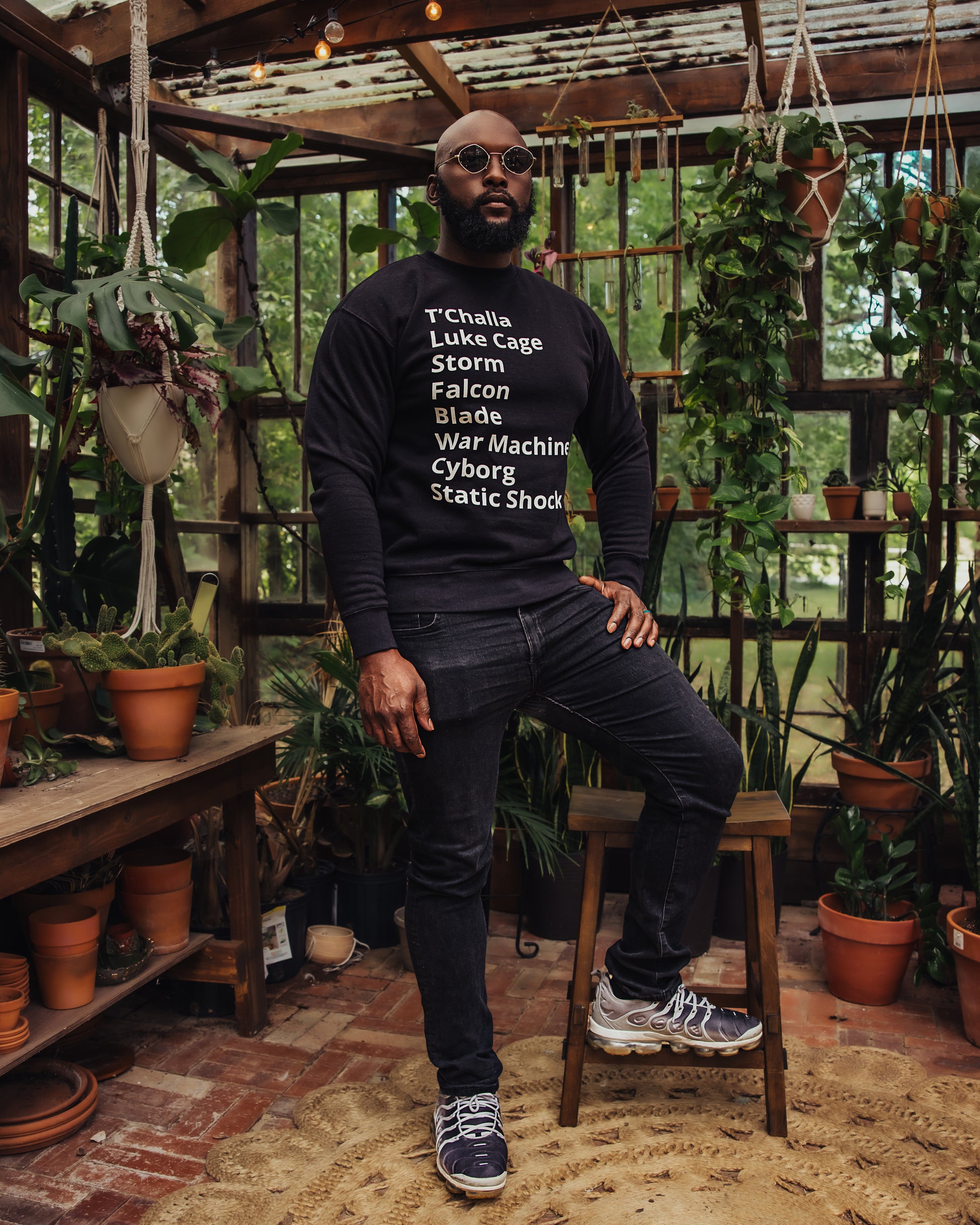 man wearing crew neck sweater with minimalist typography listing Black (African American) Super heroes from marvel and dc: T'Challa (Black Panther), Luke Cage, Storm, Falcon, Blade, War Machine, Cyborg, Static Shock.