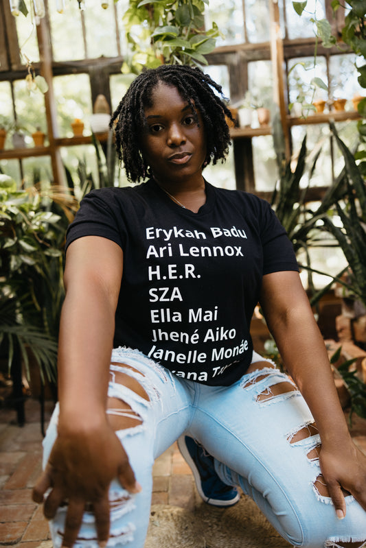 T-shirt with minimalist typography listing female R&B singers: Erykah Badu, Ari Lennox, H.E.R., SZA, Ella Mai, Jhene Aiko, Janelle Monae, and Teyana Taylor.