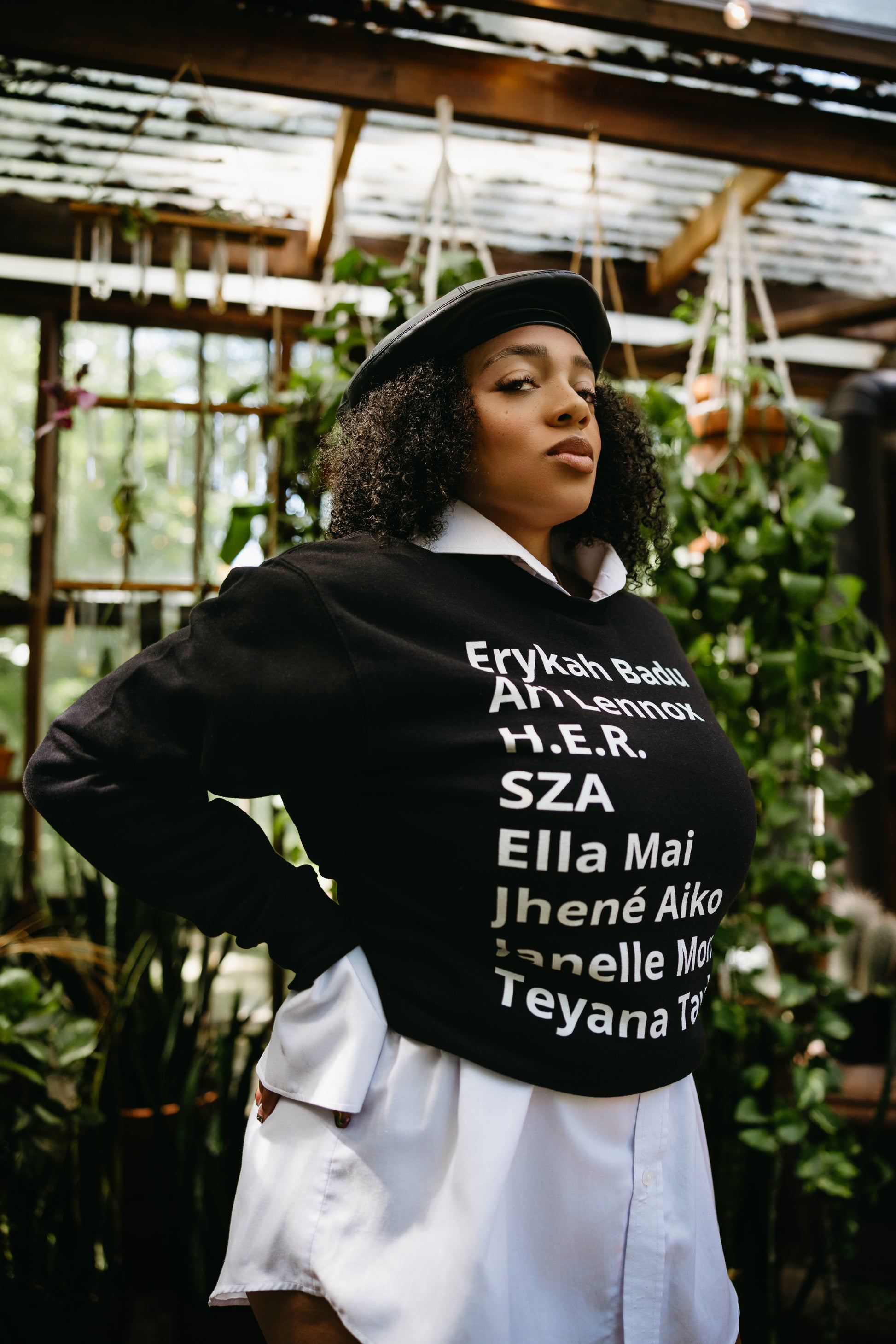 women with a burette and dress shirt - Sweater with minimalist typography listing female R&B singers: Erykah Badu, Ari Lennox, H.E.R., SZA, Ella Mai, Jhene Aiko, Janelle Monae, and Teyana Taylor.