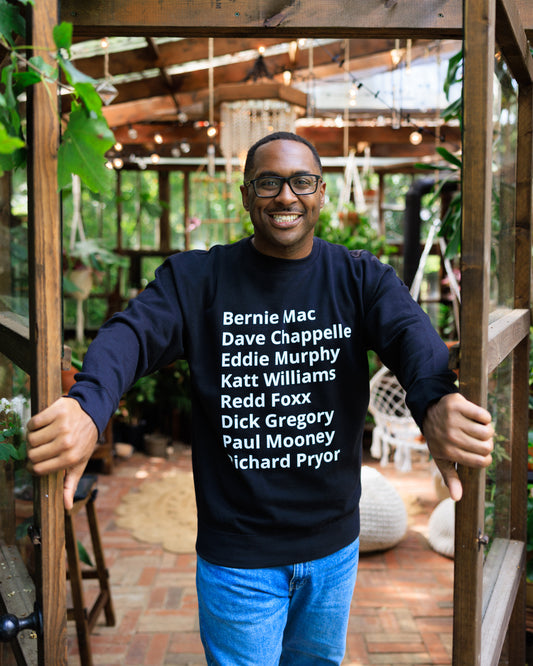 mean wearing crew neck sweater with minimalist typography listing Black comediaans: Bernie Mac, Dave Chappelle, Eddie Murphy, Katt Williams, Redd Foxx, Dick Gregory, Paul Mooney, and Richard Pryor.