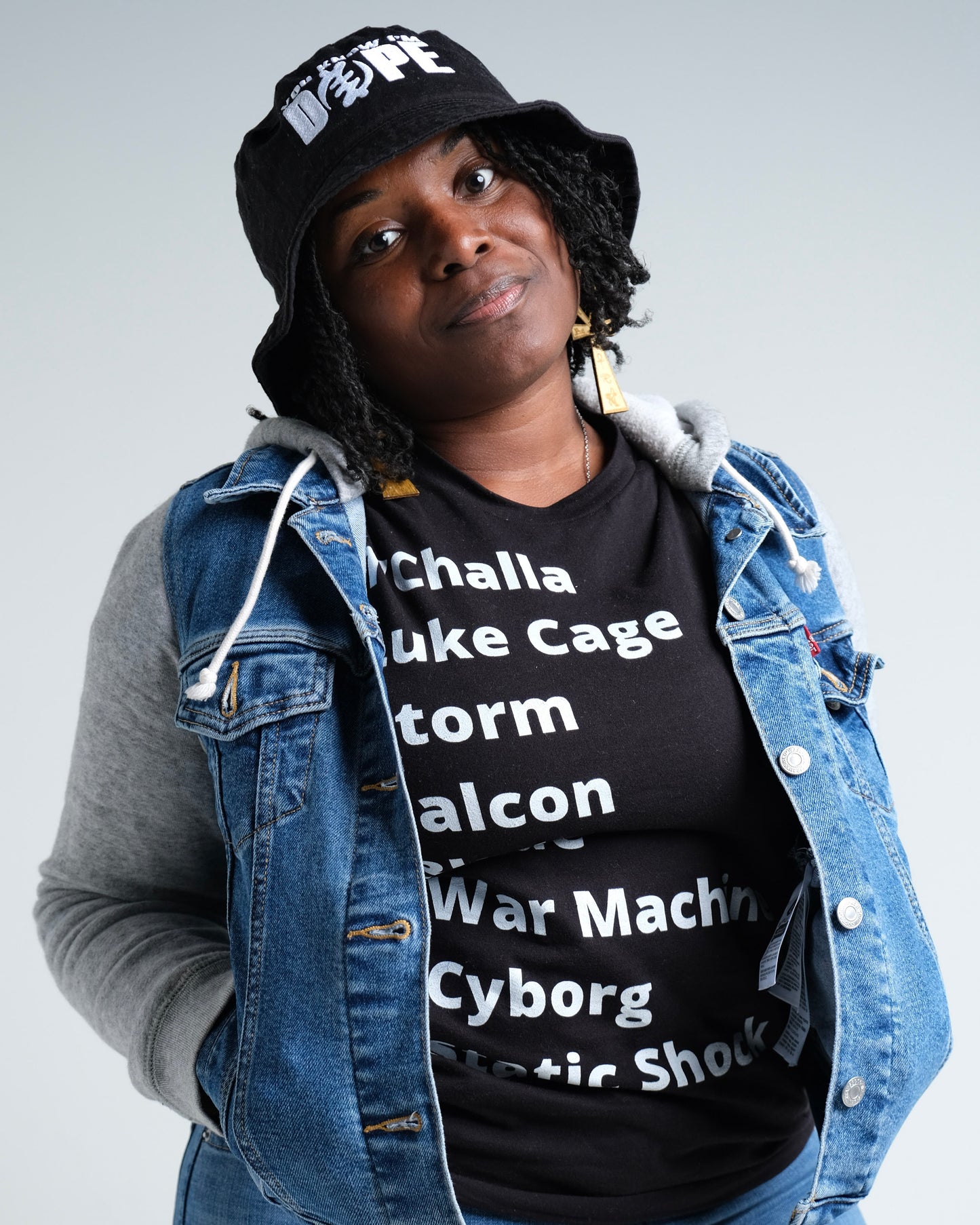 Women with T-Shirt with minimalist typography listing Black (African American) Super heroes from marvel and dc: T'Challa (Black Panther), Luke Cage, Storm, Falcon, Blade, War Machine, Cyborg, Static Shock.