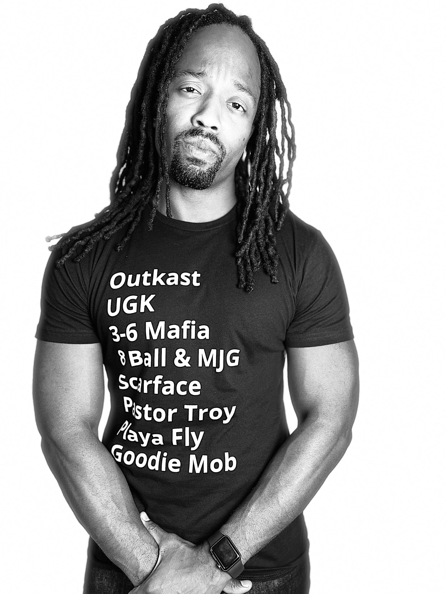 man wearing - T-Shirt with minimalist typography listing southern hip-hop rappers: Outkast, UGK, 3-6 Mafia, 8 Ball & MJG, Scarface, Pastor Troy, Playa Fly, and Goodie Mob